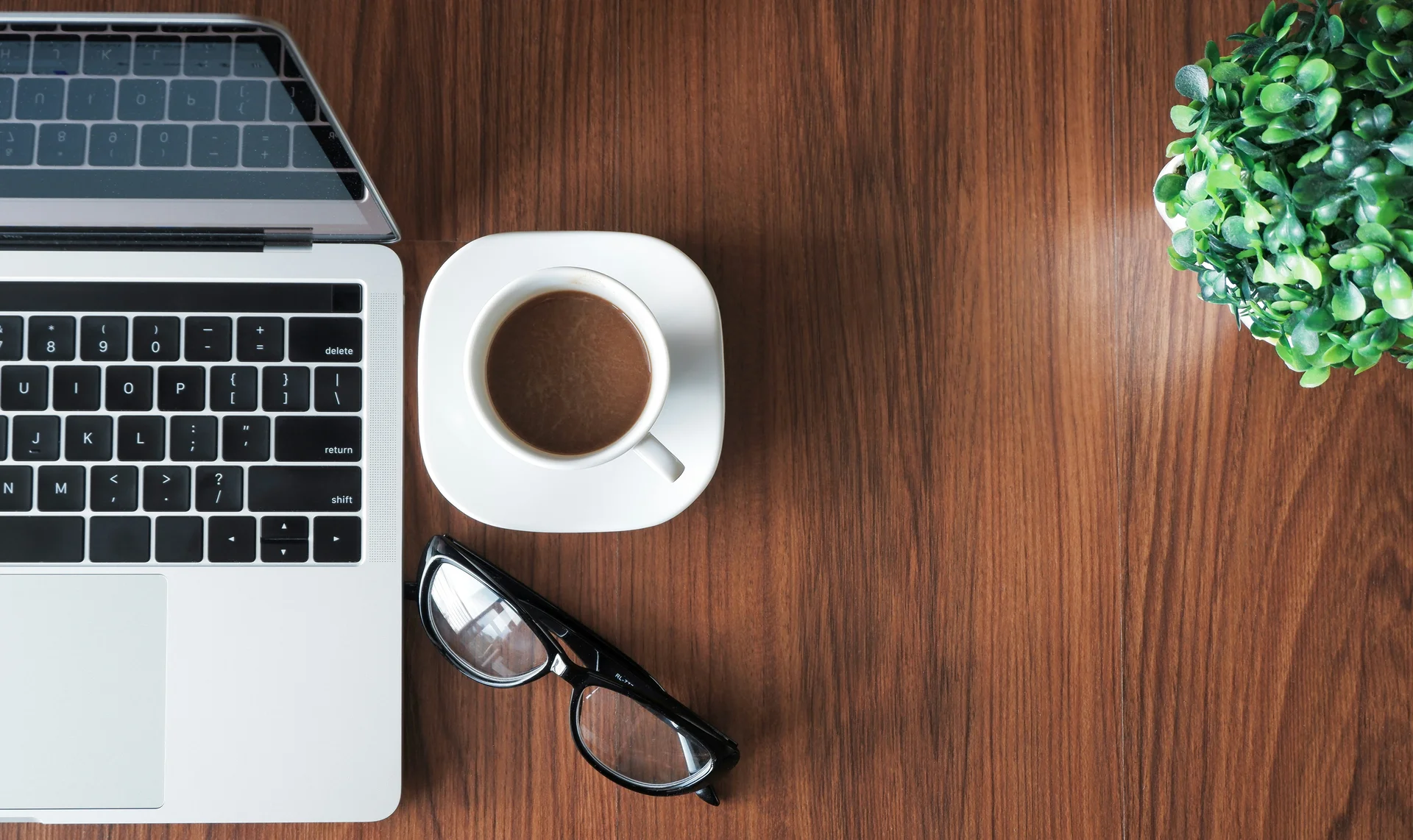Workspace with laptop, coffee, and glasses